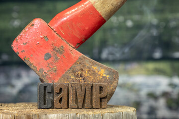 Old Rusty Hatchet with word Camp in Wood Typeface