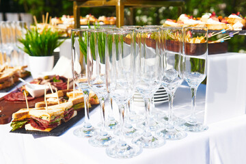 buffet in the open air - empty glasses on the background of cold snacks on the table