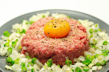 Beef steak tartare with raw egg yolk and onion with chive
