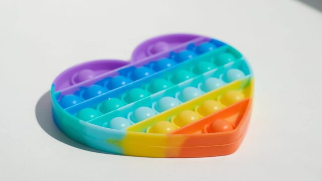 Antistress pop it toy. Rainbow sensory fidget isolated on white background. New trendy silicone toy.