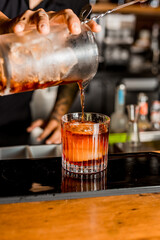 Bartender Hands Making a Perfect Negroni Drink Step by Step Recipe at the bar