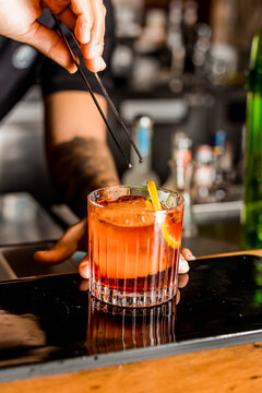 Bartender Hands Making a Perfect Negroni Drink Step by Step Recipe at the bar