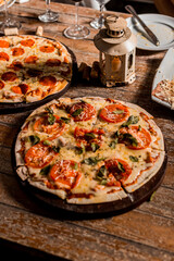 Delicious Crunchy Artisan Pizza with melted cheese on a round plate over a wooden table