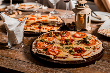 Delicious Crunchy Artisan Pizza with melted cheese on a round plate over a wooden table