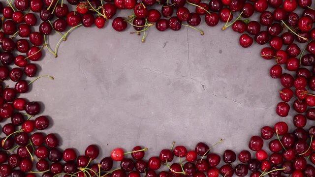 Pale of fresh organic red ripe cherries making creative frame for text. Stop motion flat lay