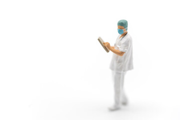 Healthcare concept. Closeup of doctor miniature figure people wearing surgical face mask and hat with patient files standing on white background.