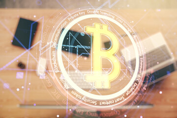 Double exposure of creative Bitcoin symbol hologram with computer on background. Mining and blockchain concept