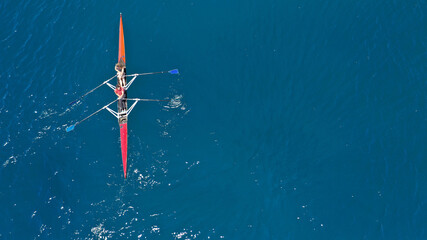 Aerial drone top down photo of sport canoe operated by team of young women in emerald calm sea waters - obrazy, fototapety, plakaty