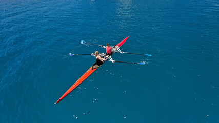 Aerial drone top down photo of sport canoe operated by team of young women in emerald calm sea...