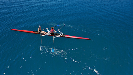 Aerial drone top down photo of sport canoe operated by team of young women in emerald calm sea waters © aerial-drone