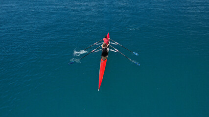 Aerial drone top down photo of sport canoe operated by team of young women in emerald calm sea...