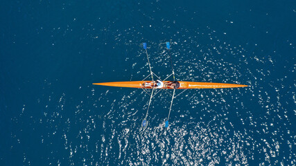 Aerial drone top down view of sport canoe operated by team of young trained athletes in deep blue Aegean sea © aerial-drone