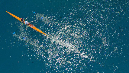 Aerial drone top down view of sport canoe operated by team of young trained athletes in deep blue Aegean sea © aerial-drone