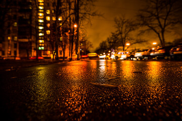 Rainy night in the big city, alley in the city. View from a wide angle at the level of asphalt