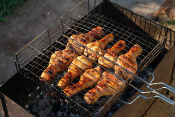 Grilled chicken meat, chicken legs on grill grid. Cooking outside as picnic time with barbecue grid