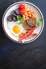 english breakfast fried egg fresh black pudding blood sausage, cereal bread, beans, bacon, scrambled eggs food healthy meal snack copy space food background rustic top view