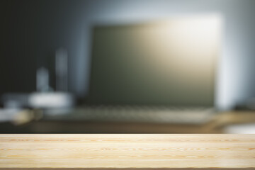 Empty office wooden desktop with empty space on modern night workplace with computer screen and lamp background, closeup, mock up