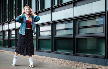 Young blonde woman roller skating listening to music on headphones.