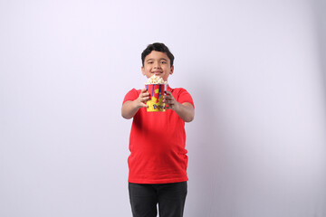  happy little Indian boy eating popcorn 