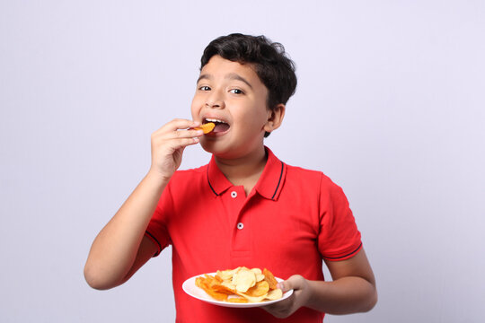  Indian Kid or boy eating potato chips or wafers.