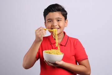 Indian kid or boy eating noodles.