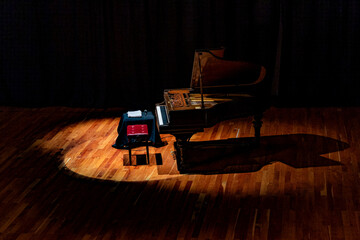 Musical instrument. Beautiful Piano on stage with overhead spot lighting.