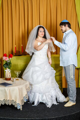 During a chuppah ceremony at a Jewish synagogue wedding, the groom puts a ring on the bride's index finger.