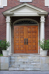 Elegant entrance with wood grain double door and portico