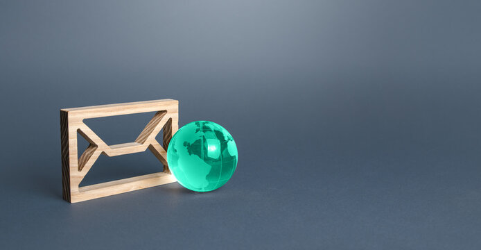 Wooden letter envelope and earth globe. Communication over network. Business promotion and feedback. Providing links and contacts on various public platforms and sites.