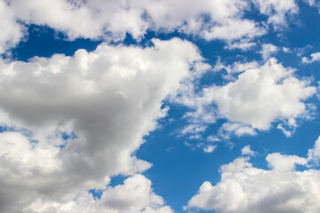 white fluffy clouds on the blue sky on a summer sunny day