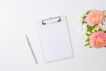Mockup clipboard white and pink flowers in a vase on a light background