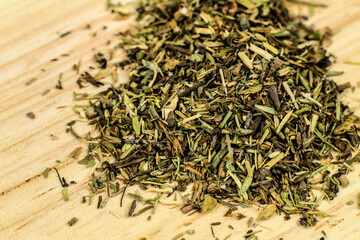 Dried thyme spilled on brown wooden board