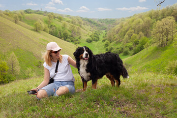 Friendship between a girl and dog. Border Collie with an owner in beautiful green hills covered...