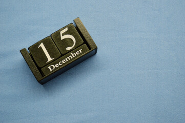 Wooden calendar from blocks on a blue background with copy space. December 15th