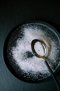 Salt on black plate with a spoon