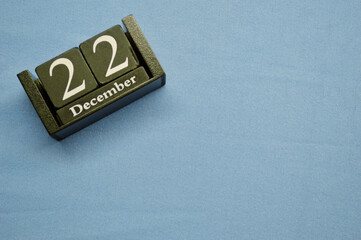 Wooden calendar from blocks on a blue background. twenty second of December