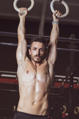 Fototapeta na wymiar young man training inside a gym with functional exercise. athlete body