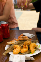 Fotografia vertical de un plato de fritura de pescado con limon