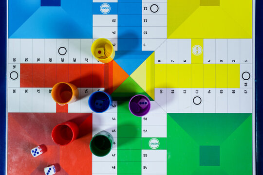 Tablero de parchis con fichas de colores y dados