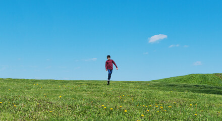 A little boy walks in a city park