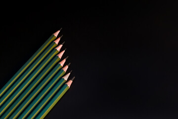 Simple pencils lie on a black background