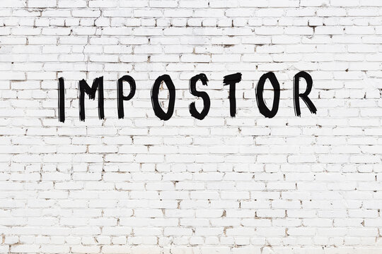 White wall with black paint inscription impostor on it
