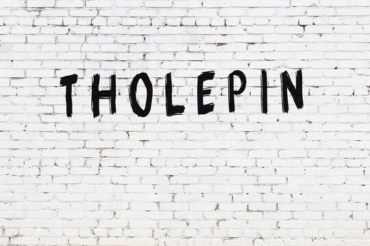 White wall with black paint inscription tholepin on it