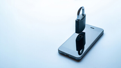 Internet protection. Modern space grey mobile phone with padlock, key on white background. Darkweb, darknet and hacking concept.