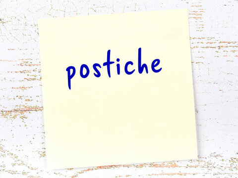Yellow sheet of paper with word postiche. Reminder concept