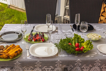 Close up view of served table with grilled food and greens on plate. Sweden.