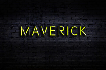Neon sign. Word maverick against brick wall. Night view