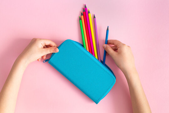 Rainbow Multicolored Pencils In A Blue Pencil Case In The Hands Of A Child On A Pink Background. Stationery, School Supplies. Concept Back To School, Preschool Education. Mockup, Copy Space.