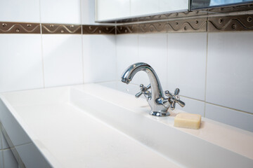 chrome basin faucet, water valve in interior of bathroom