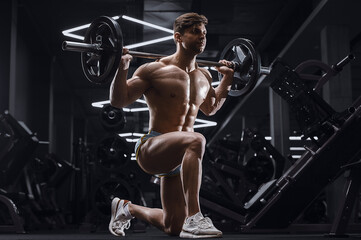 Fototapeta na wymiar athletic man pumping doing lunges exercises in gym